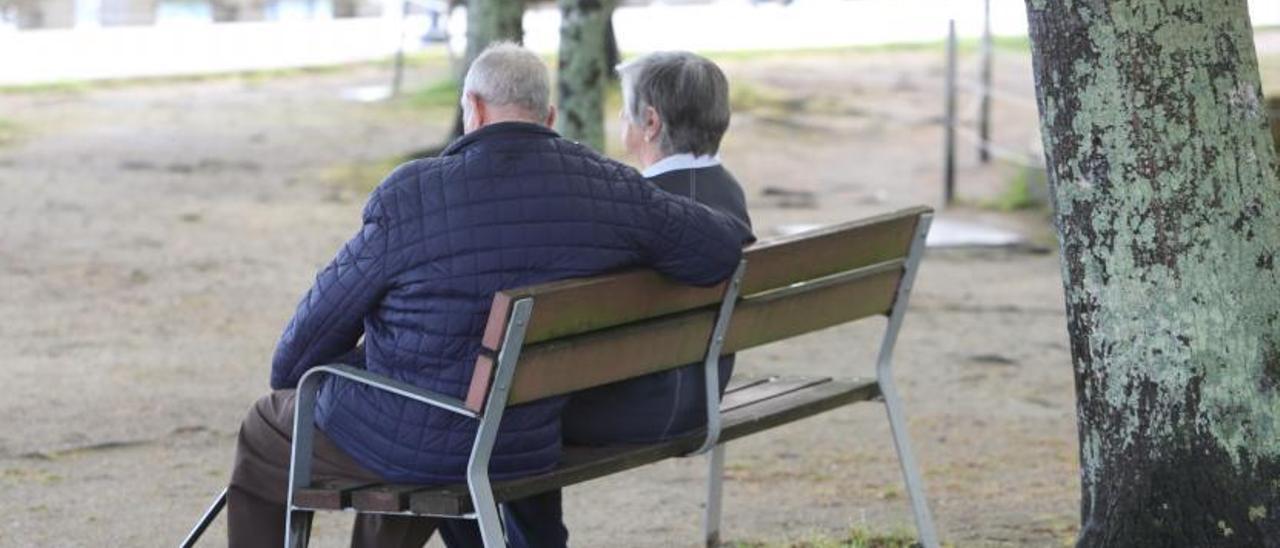 Dos personas mayores sentadas en un banco en Cangas. |   // SANTOS ÁLVAREZ