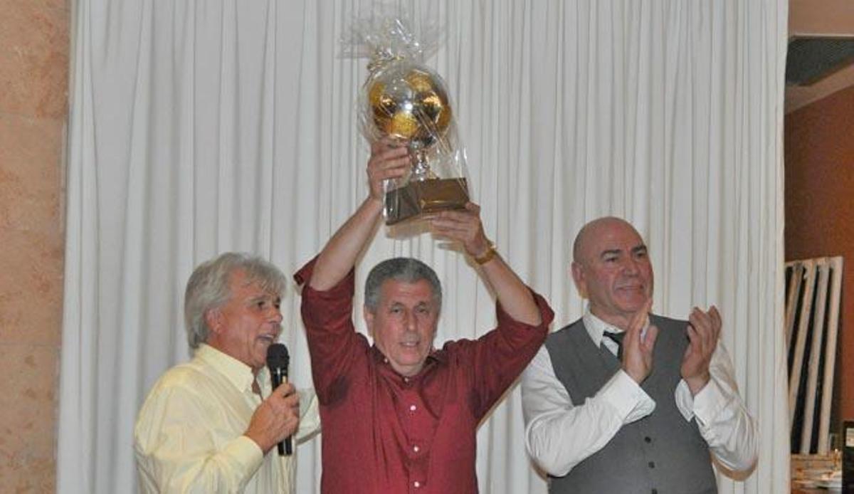 Miguelín levanta el balón de oro que le obsequiaron junto al presidente del Luchador, Fernando Roa, y Juan Mesa.