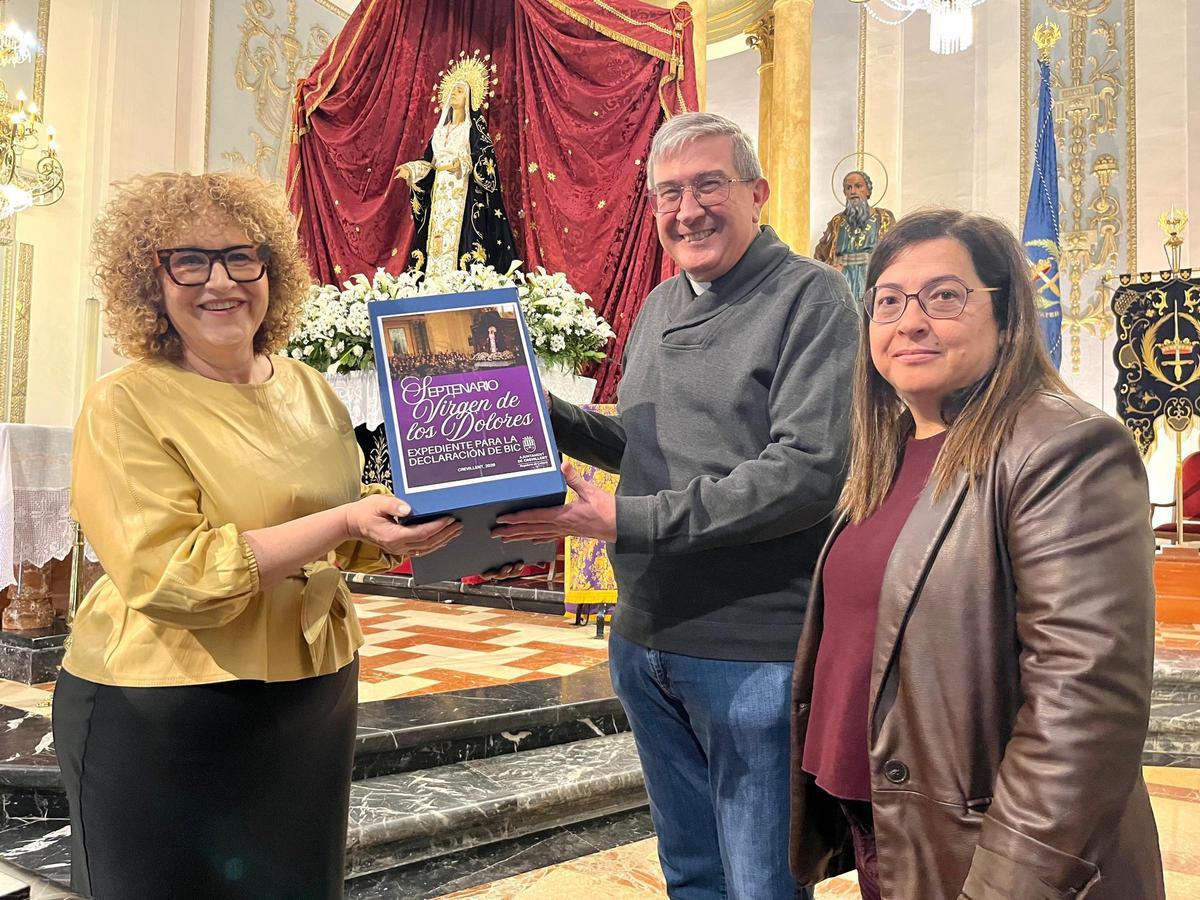 La edil y la técnica de Cultura, junto al párroco de Belén, muestran el expediente sobre el Septenario de los Dolores de Crevillent