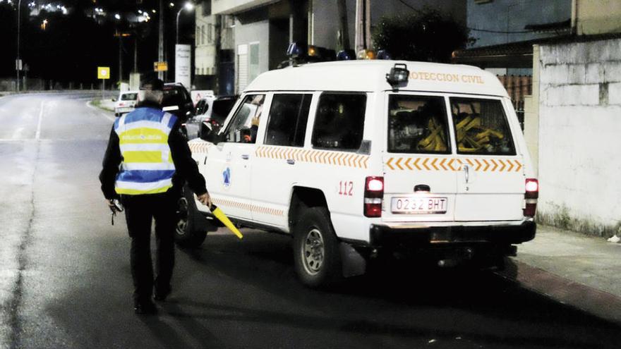 Agentes de la Policía Local ante el coche de Protección Civil.