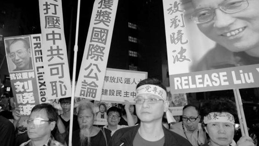 Activistas por la democratización de China se manifiestan en Hong Kong para pedir la liberación de Liu tras conocer la concesión del Nobel de la Paz al disidente. Sobre estas líneas, Liu, en un fotografía difundida por su familia el pasado día 3.