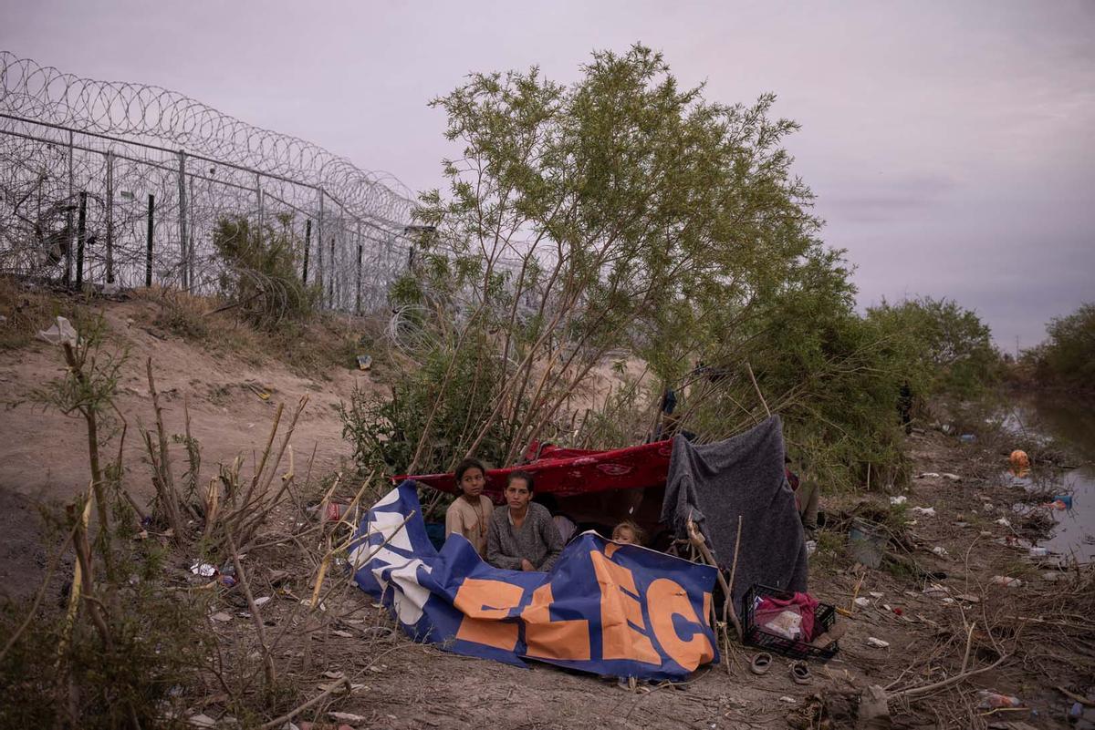 Migrantes acampan a lo largo de la orilla del río Grande mientras esperan entregarse a las autoridades de inmigración en El Paso, Texas, EE.UU