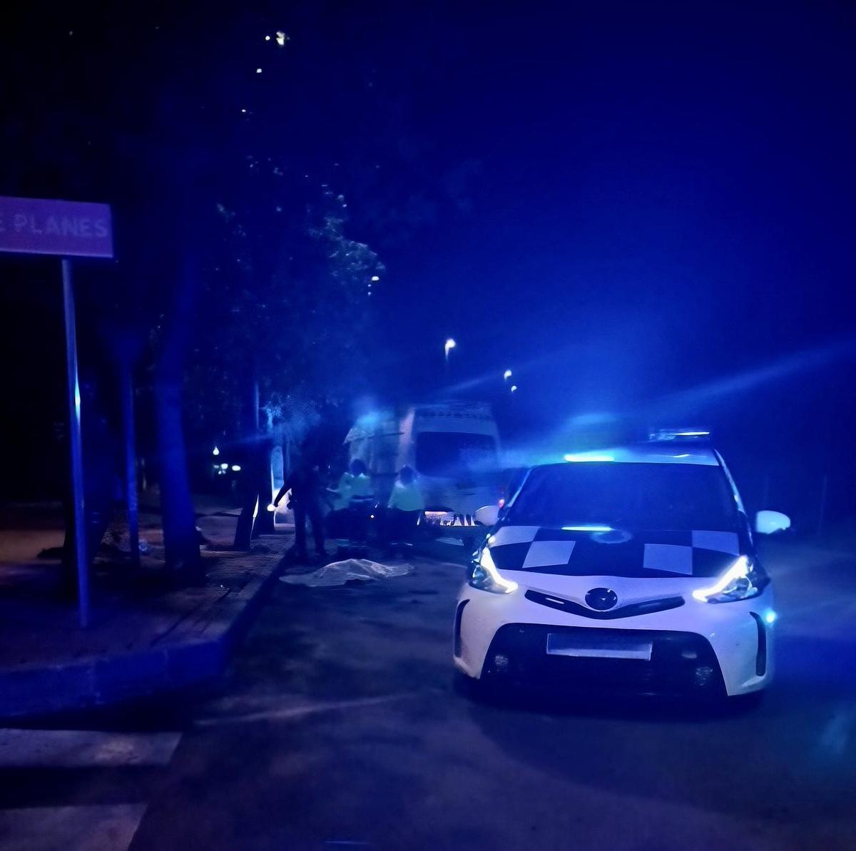 Una ambulancia y un coche policial junto a una bolsa blanca.