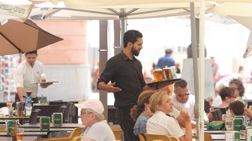 Un camarero atiende a los turistas en una terraza de Cartagena.