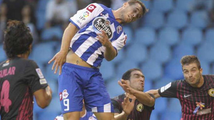 Un jugador del Deportivo remata de cabeza.