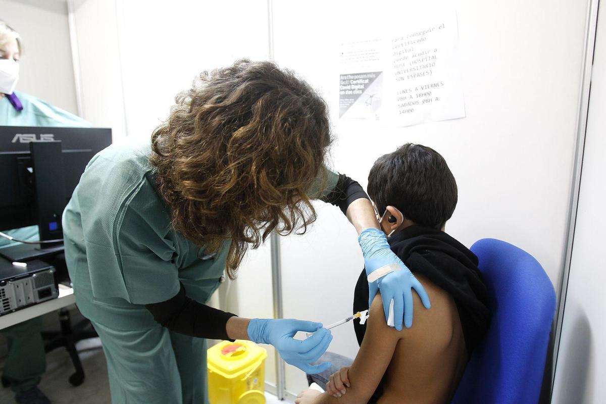 Una sanitaria vacuna a un niño contra el coronavirus.