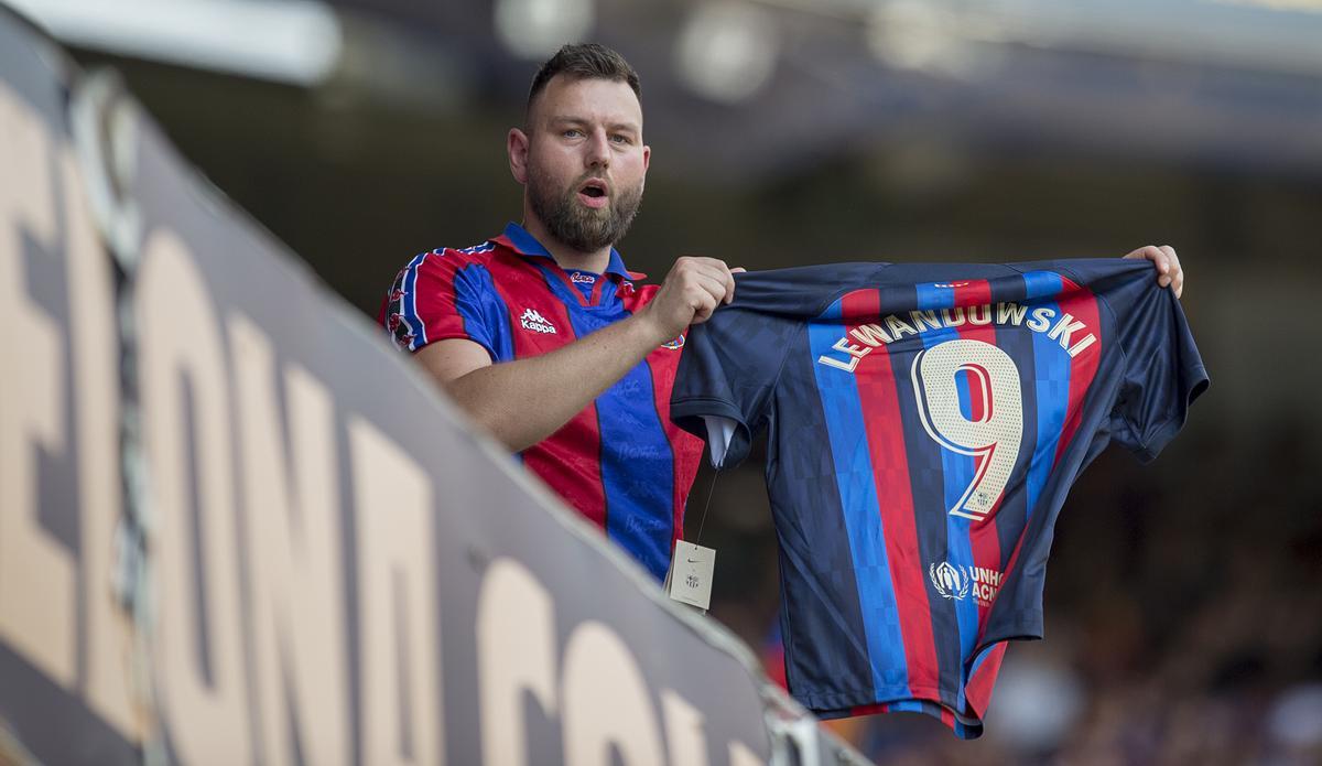 Un aficionado exhibe la camiseta azulgrana con el nombre de Robert Lewandowski y el número 9 en la espalda en el Camp Nou.