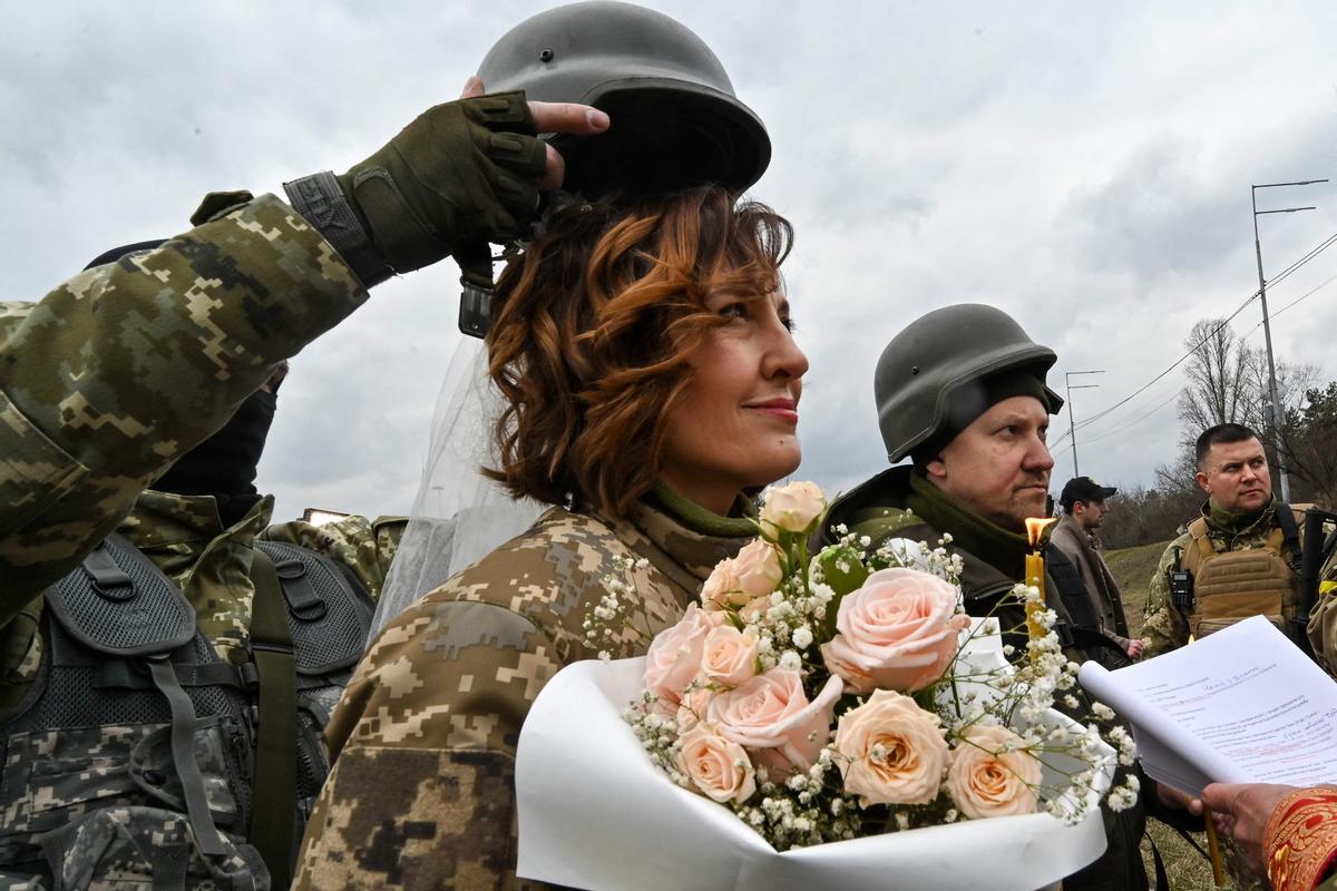 Lesya y Valery, ambos militares de la Defensa Territorial de Ucrania, se casan cerca de un puesto de control en las afueras de Kiev.