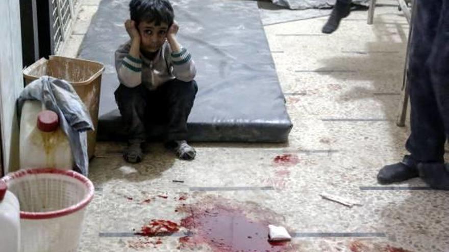 Un nen espera per rebre tractament al costat d&#039;una bassa de sang en un hospital de Síria.