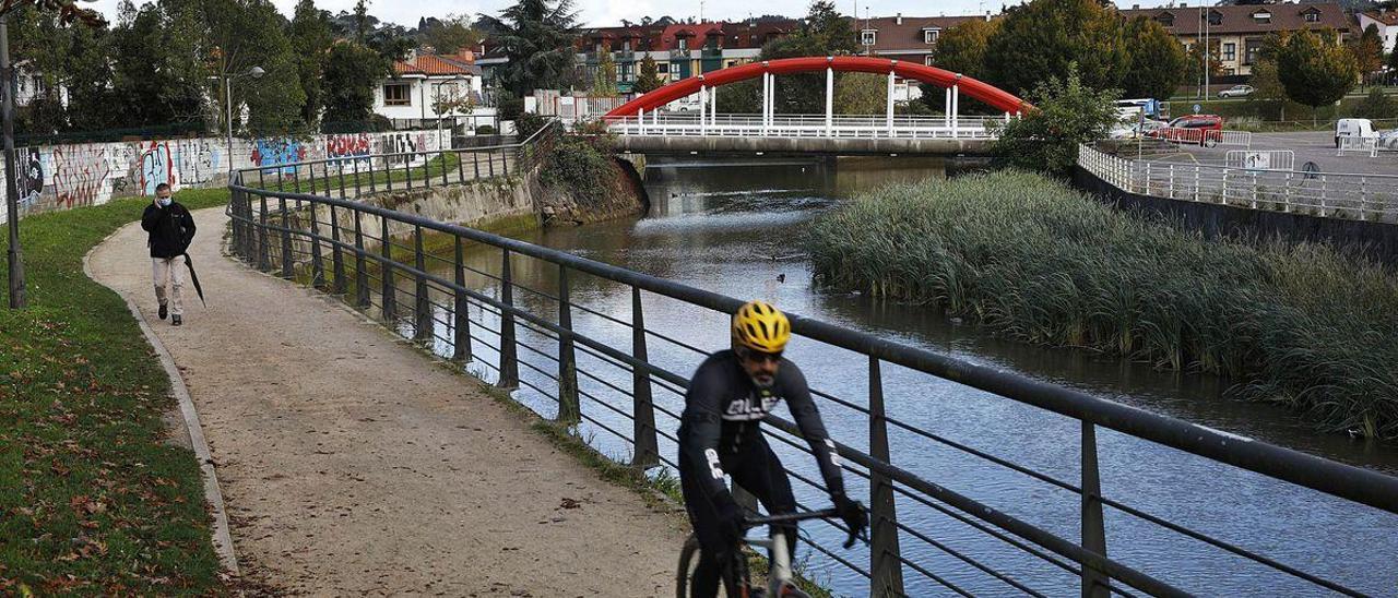 Un ciclista pasa junto al cauce del río Piles.