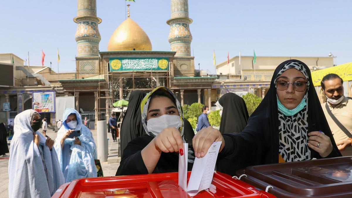 Dos mujeres depositan su voto en una urna en Teherán en las elecciones presidenciales de Irán.