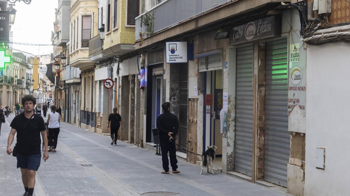 Una de las calles de Paiporta, con negocios abiertos y cerrados, un año después de la dana.