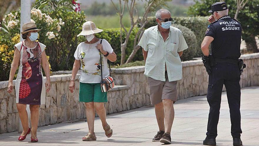 Transeúntes paseando ayer por las calles de València con la mascarilla puesta.