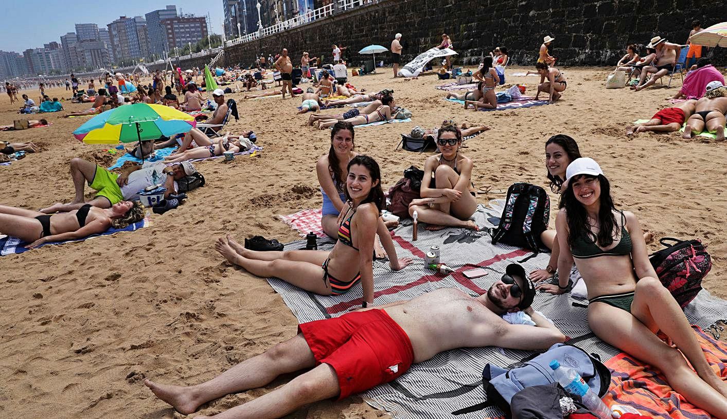 Lorenzo Ramos, tumbado, junto a Inés Marcos, Laura Ramos, Anne Recke, Lucía Ramos y María Arbelo, ayer, en la playa de San Lorenzo, en Gijón. | Juan Plaza