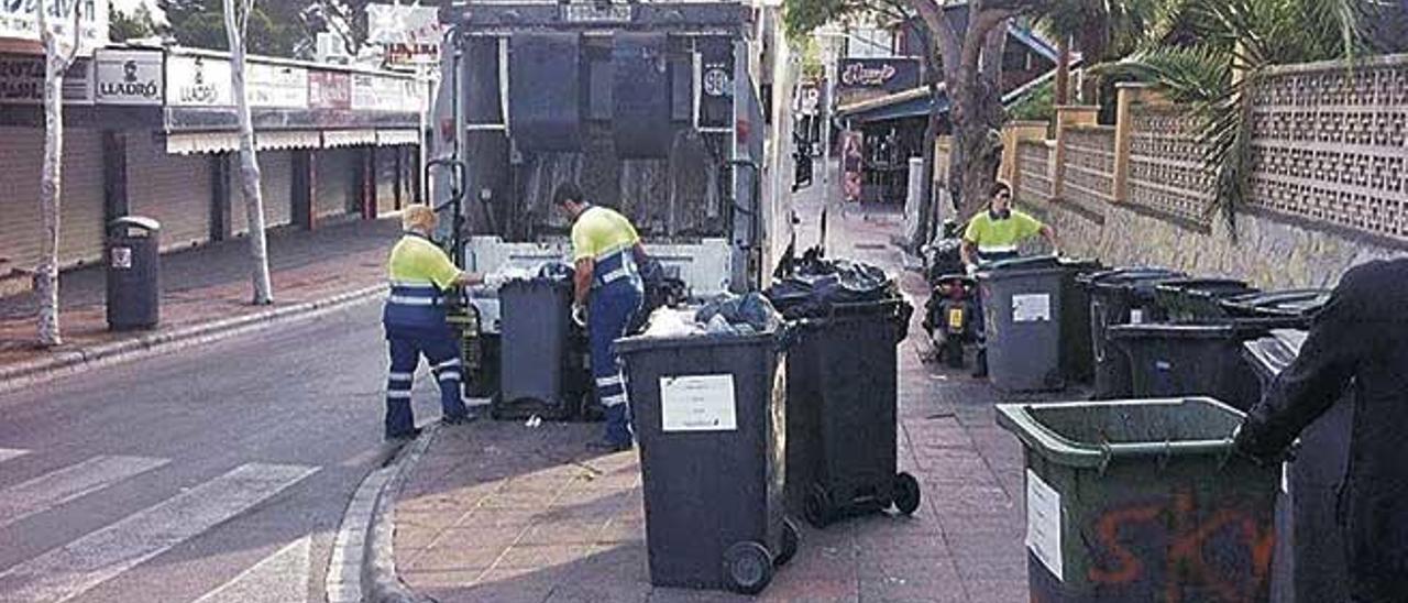 Operarios de la empresa municipal Calvià 2000 recogen cubos de basura en una calle del municipio.