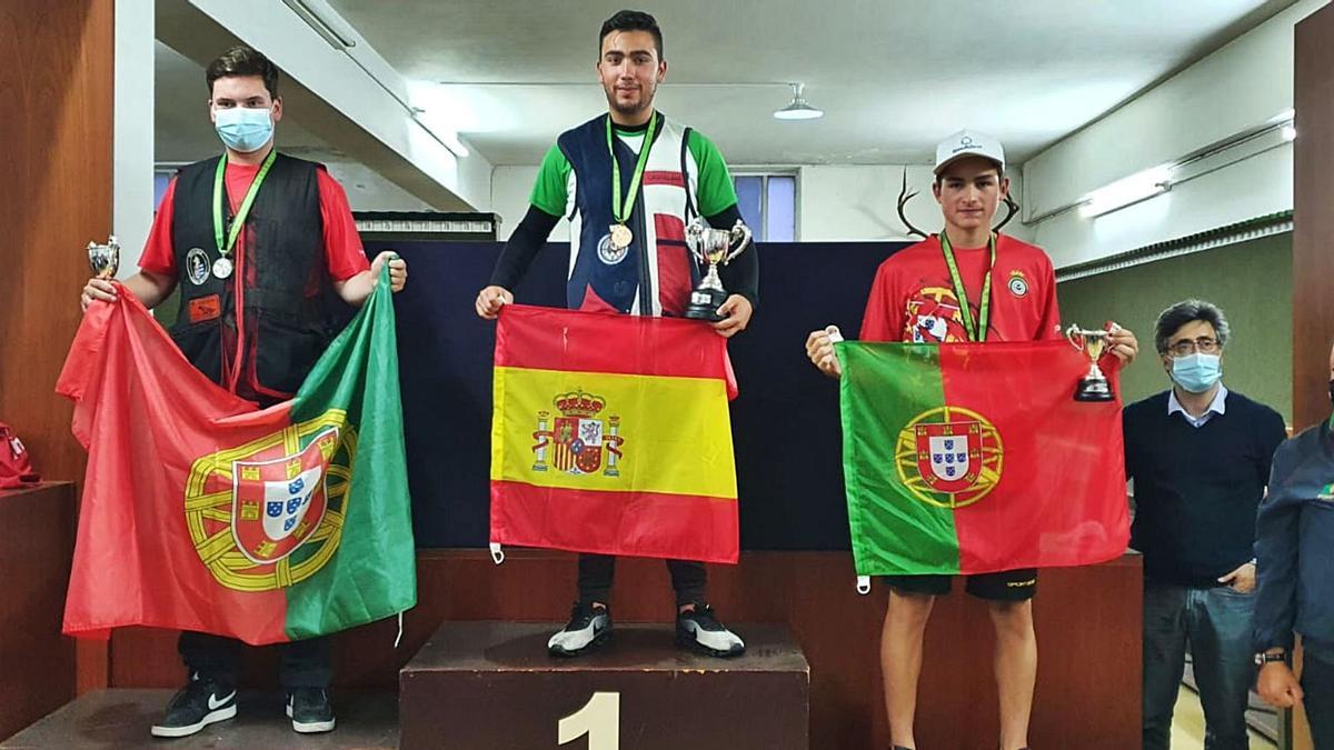 David Sotelo con la bandera de España en lo alto del podio del Campeonato de Europa júnior de tiro al plato de Guimaraes, junto a sus rivales portugueses a los que venció. | Cedida 