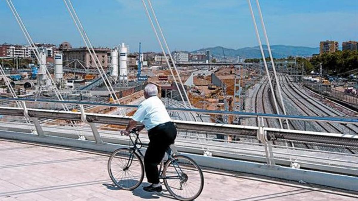 Un hombre pasea en bicicleta por los aledaños de la futura estación, en el puente de Bac de Roda, el pasado 18 de mayo.