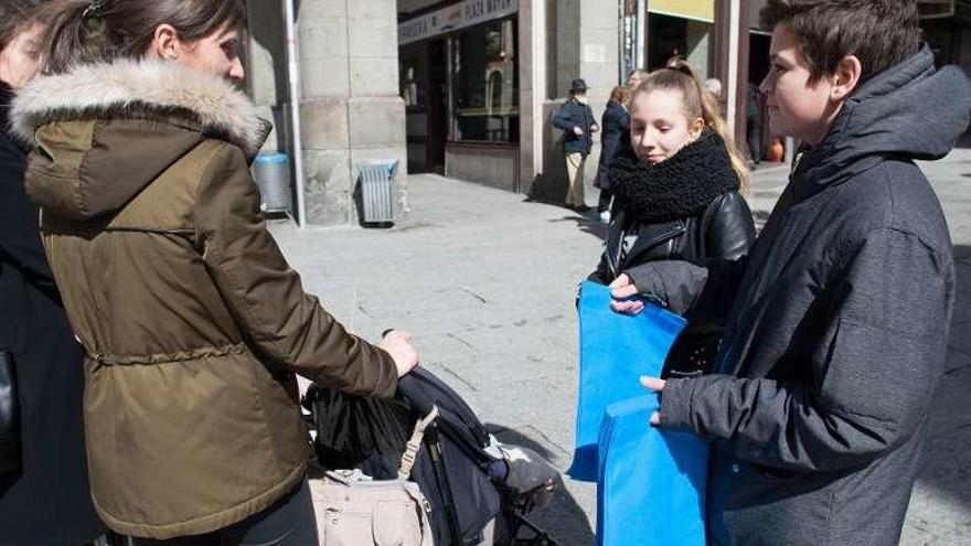 Dos alumnos del centro explican la iniciativa a los viandantes.