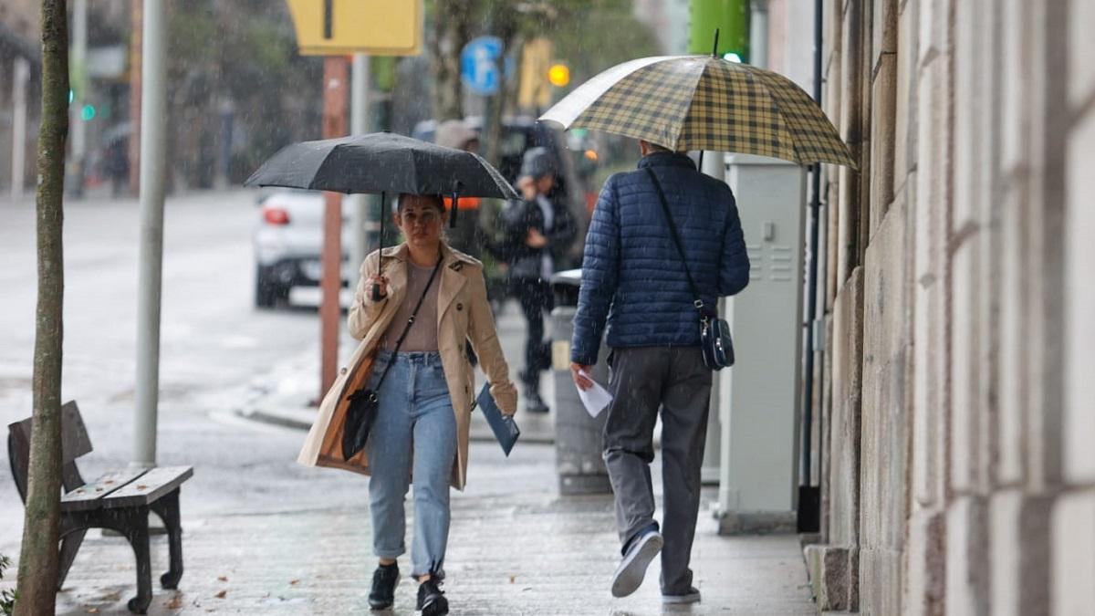 Una joven se protege de la lluvia, esta mañana en Vigo