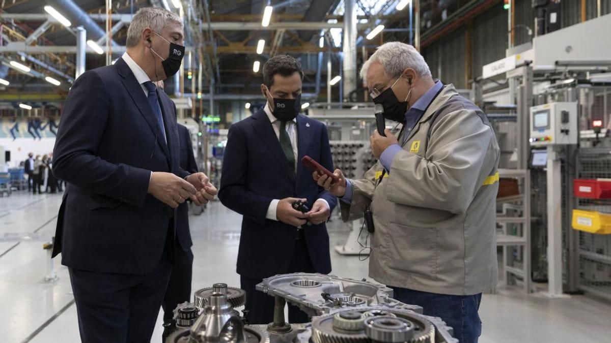 Juanma Moreno (c), con el director general del Renault Group, José Vicente de los Mozos y un empleado. | MARÍA JOSÉ LÓPEZ (EUROPA PRESS)