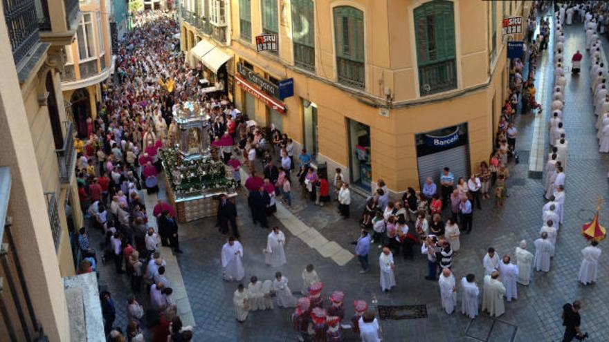 La carroza con su Divina Majestad, precedida por el clero malagueño, en la curva de las calles Granada y Méndez Núñez.