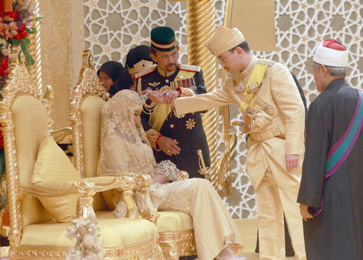 Momento en que el novio toca la cabeza de la novia ayudado por su padre, el sultán de Brunei.