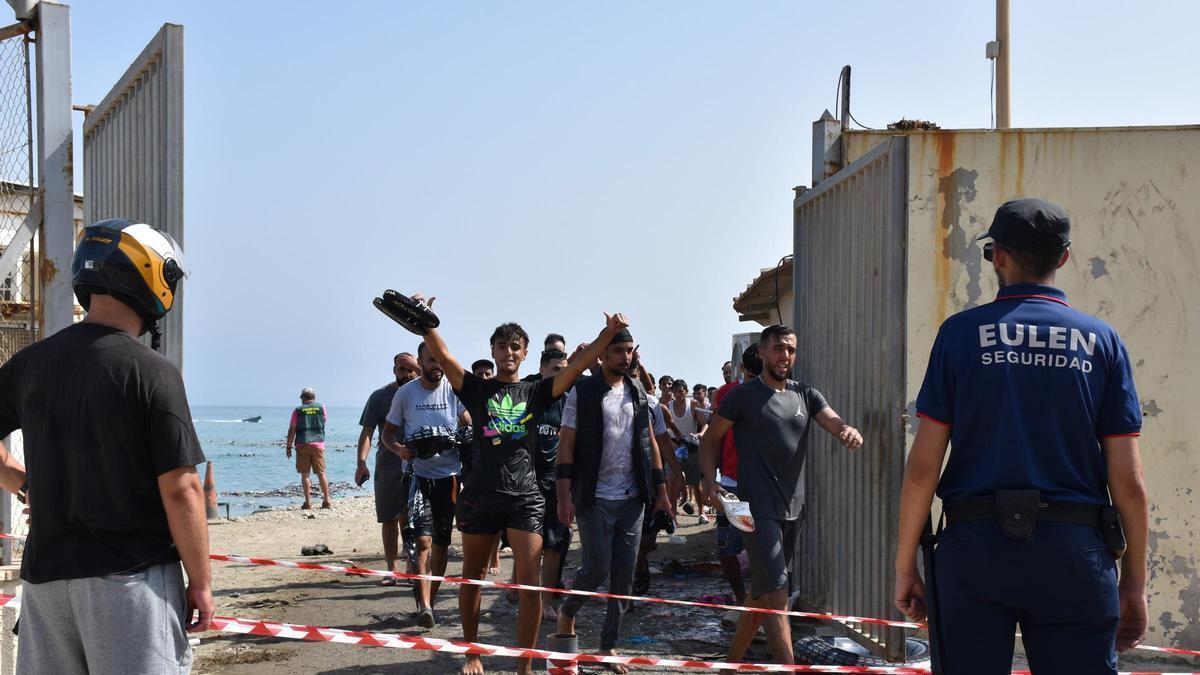 Varias personas cruzan la frontera, a 30 de julio de 2026, en Ceuta (España). Centenares de personas de origen magrebí han cruzado a lo largo de la mañana de hoy a Ceuta desde Marruecos, a nado y por el espigón, y una multitud está esperando al otro lado