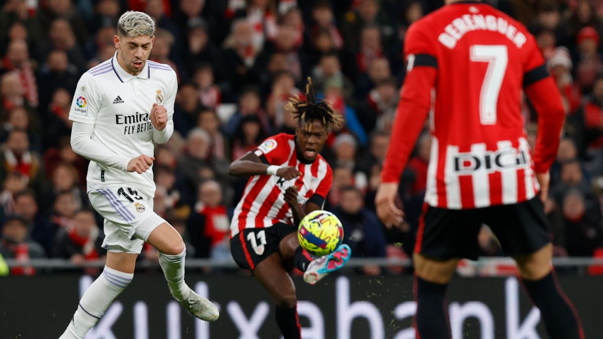 El centrocampista del Athletic Nico Wiliams efectúa un pase ante el centrocampista uruguayo del Real Madrid Fede Valverde durante el partido de LaLiga que se disputa este domingo en San Mamés.