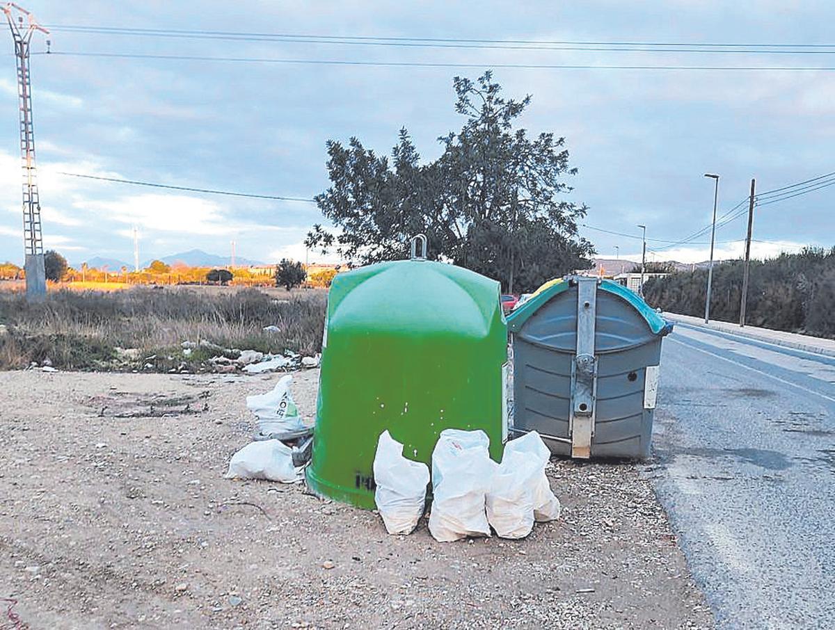 Bolsas de escombros depositadas junto a contenedores.