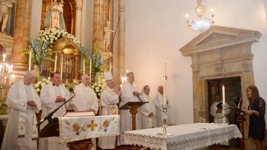 Digna Rivas (derecha) dirige su ofrenda a la Virgen ante los siete sacerdotes. // Rafa Vázquez