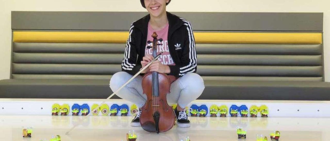 María Santos, en su laboratorio del Georgia Tech, posa con su violín y varios robots.