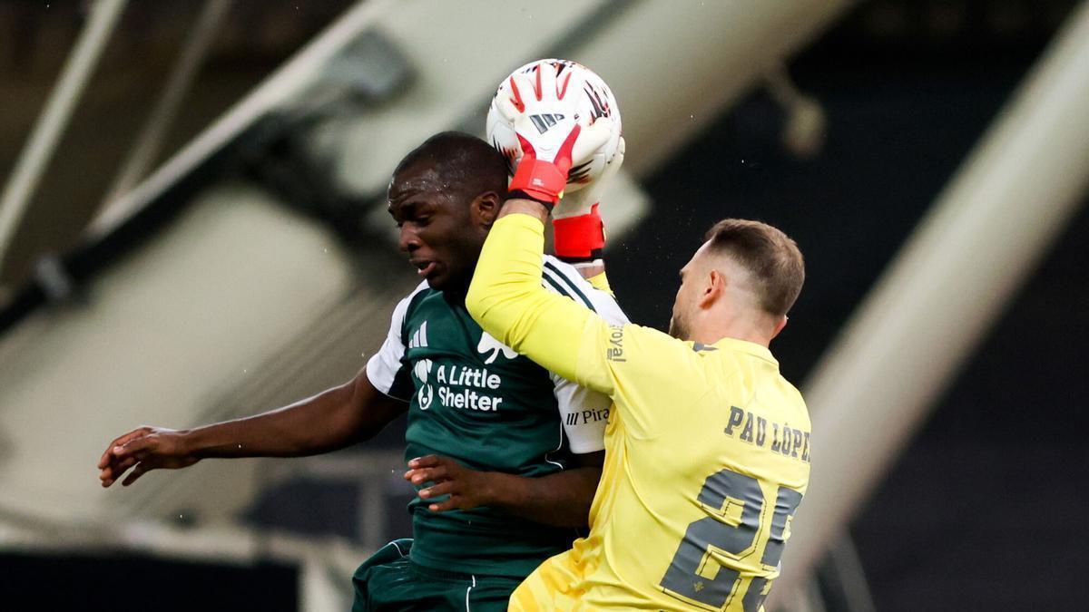 Pau López bloca un balón en el aire ante Tetteh en el Panathinaikos-Betis de octavos de Europa League en Atenas