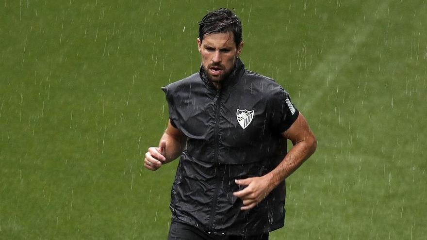 Los jugadores del Málaga CF se ejercitaron ayer sobre el verde de La Rosaleda y el Anexo bajo una intensa lluvia.