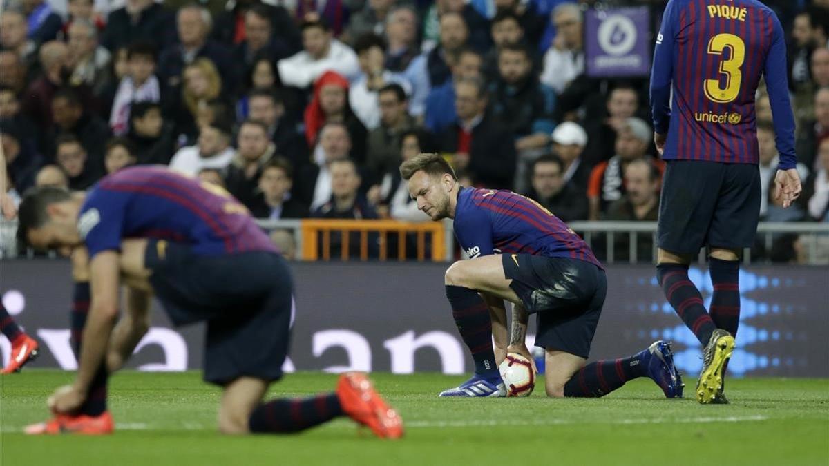 Rakitic, en el Bernabéu entre Busquets y Piqué.