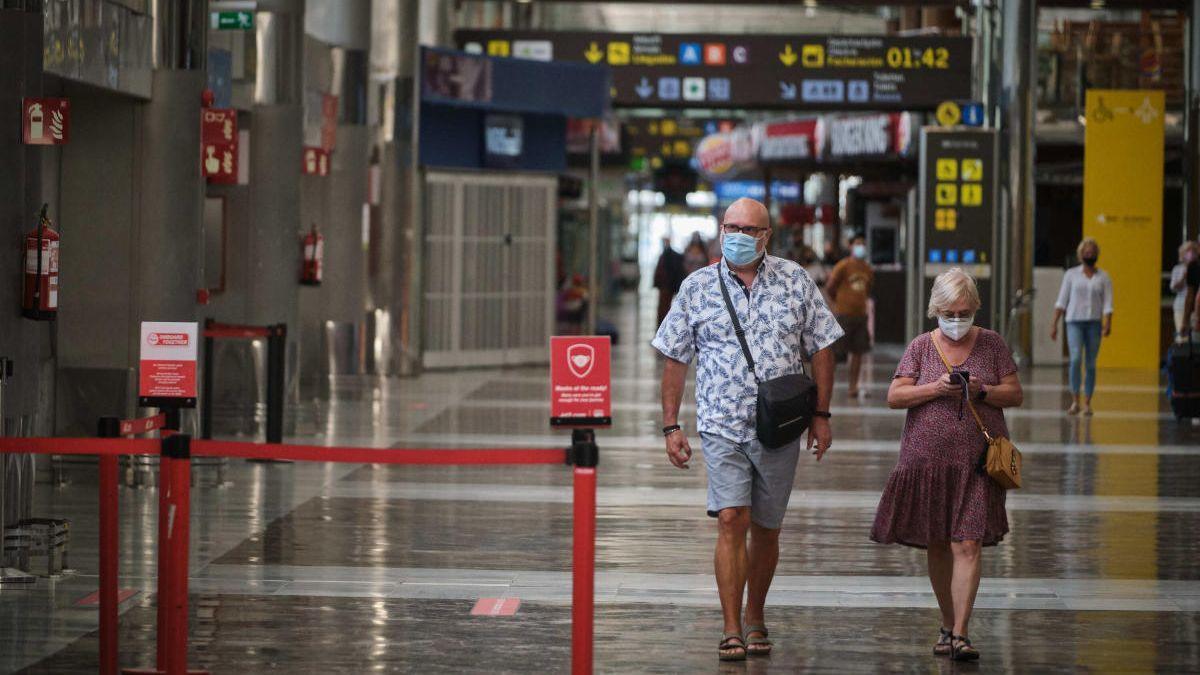 Dos turistas caminan por el aeropuerto Tenerife Sur.