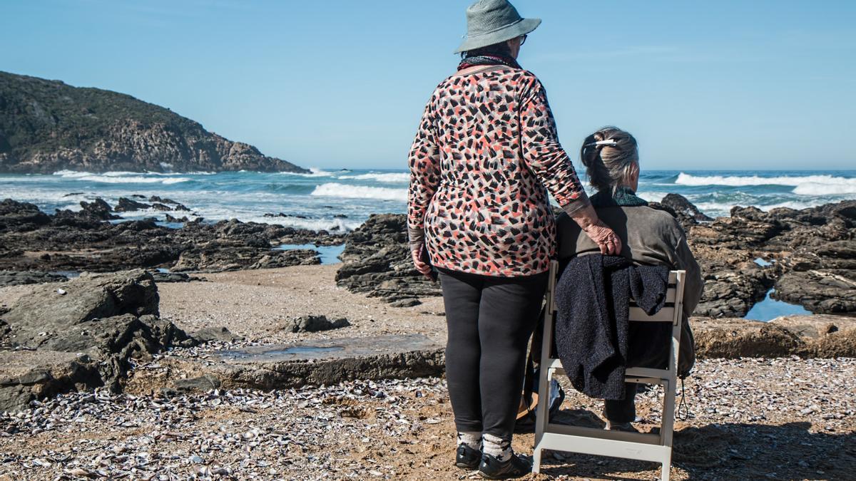 Rentner am Meer: Zwei Frauen blicken an der Küste auf das Wasser.