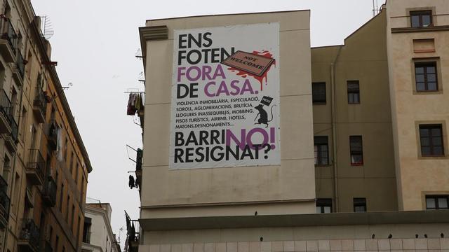 Gran pancarta contra los problemas inmobiliarios de Barcelona, en la plaza dels Àngels.