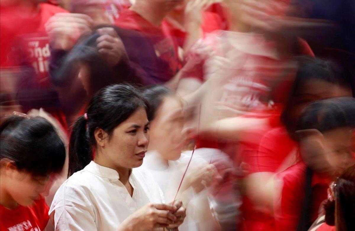 Una mujer sostiene una varita de incienso en un templo en Biondo, Manila (Filipinas).
