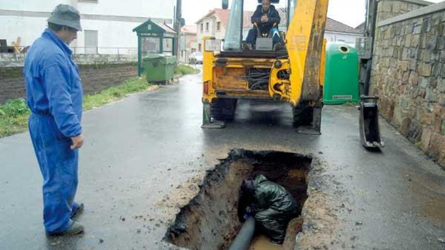 Obras de reparación de la tubería que rompió ayer en Guillán y dejó sin agua a los vecinos.