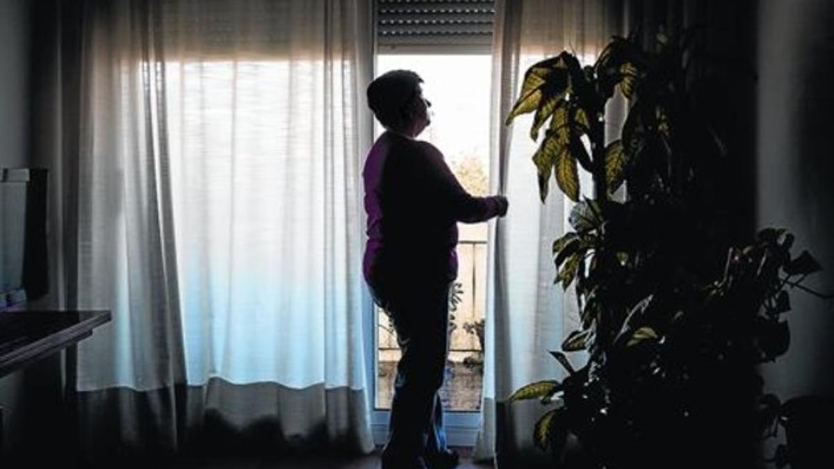 Maria corre las cortinas del salón de su casa, en el Vallès Oriental.