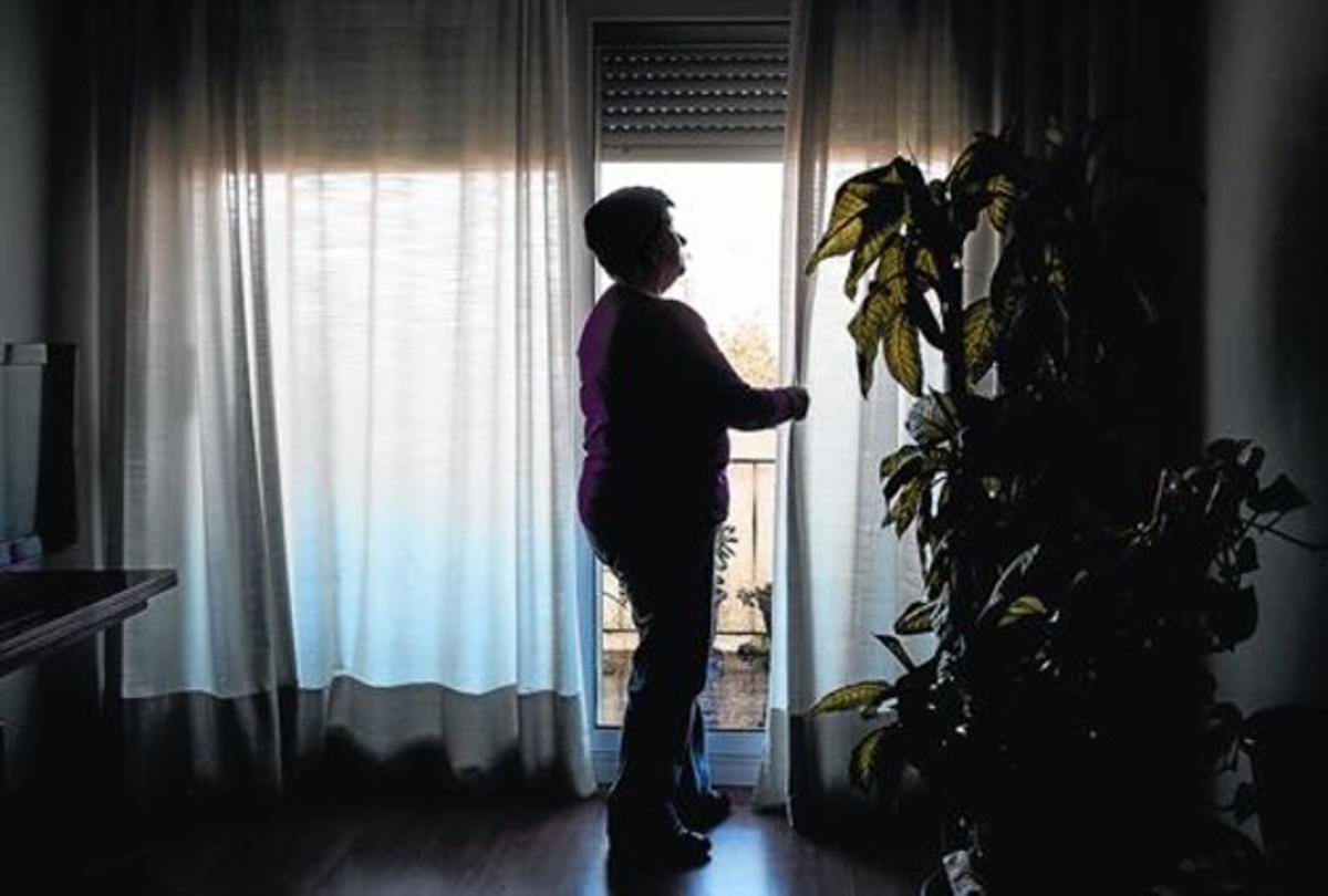 La Maria correles cortines de la sala de casa seva,al Vallès Oriental.