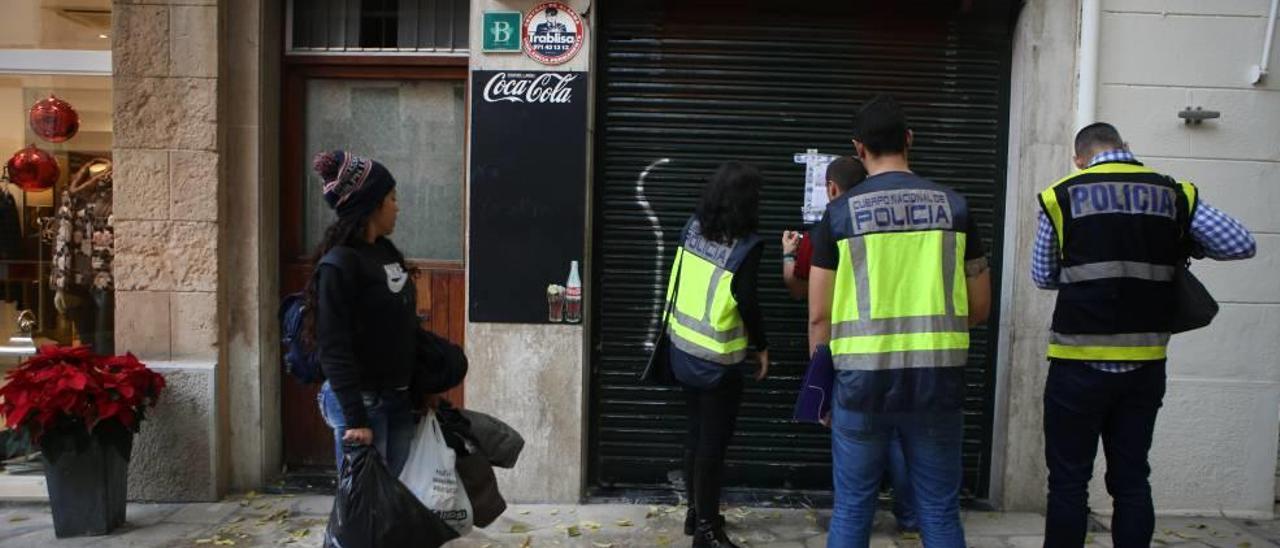 Varios agentes precintan uno de los establecimientos clausurados por orden judicial.