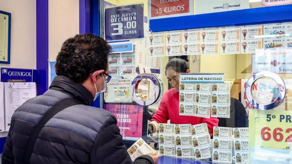 Una persona compra un décimo de la Lotería de Navidad