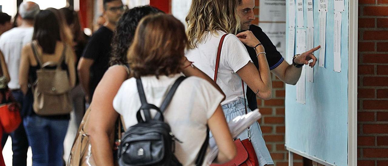 Algunos de los candidatos y candidatas consultan las listas en una convocatoria pasada. | EFE/MANUEL BRUQUE