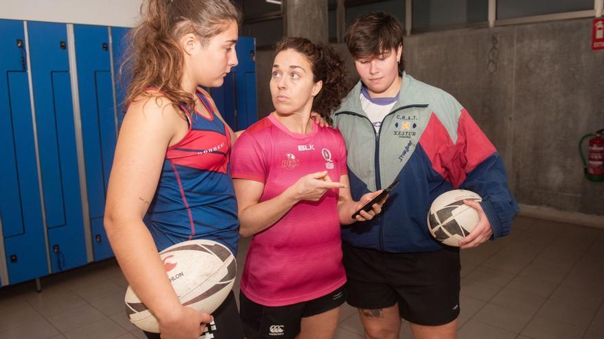 Oihane López, Elsa Porto y Mencía Martínez, jugadoras del CRAT, miran la pantalla de un móvil en los vestuarios de Elviña. |  Casteleiro