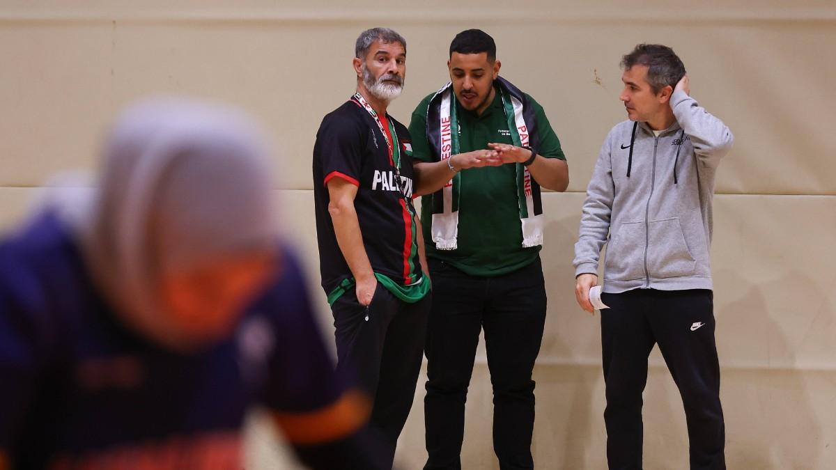 Majdi, junto a su traductor y el entrenador del equipo 'S. XXI', observa el entrenamiento de su equipo