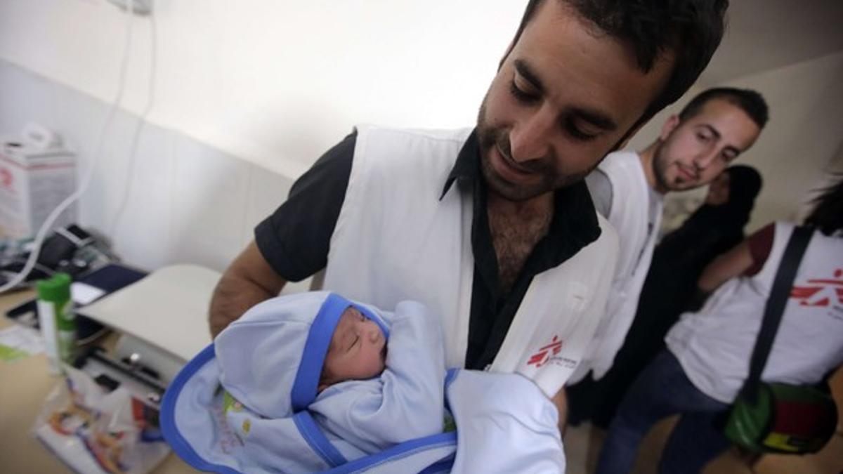 Un miembro de Médicos sin Fronteras atiende a un recién nacido en un campo de refugiados sirios, el pasado abril.
