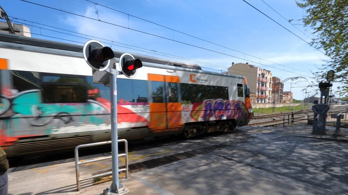 Un tren de rodalies transitant pel pas a nivell de l'avinguda Vilallonga de Figueres en una imatge d'arxiu.