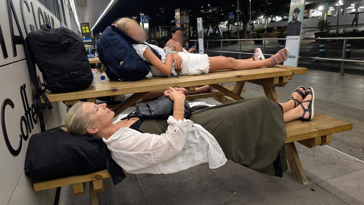 Pasajeras del vuelo FR2085 durmiendo en la entrada del aeropuerto de Ibiza.