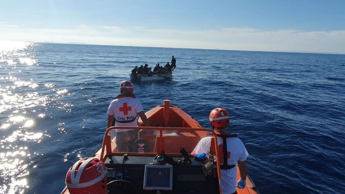 Personal de Cruz Roja rescata una patera en el mar.